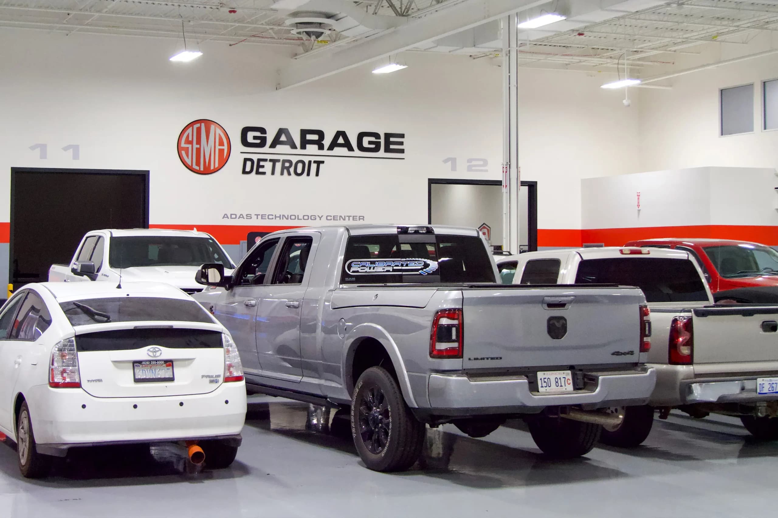 <em>Vehículos esperan ser sometidos a pruebas de investigación y cumplimiento en el Detroit Garage de SEMA en Plymouth, Michigan, el 28 de julio de 2026. El Detroit Garage de SEMA ofrece pruebas de cumplimiento para productos de posventa vendidos en 49 estados, como se puede apreciar en Plymouth, el 28 de julio de 2026. (Travis Gillmore/The Epoch Times).</em>