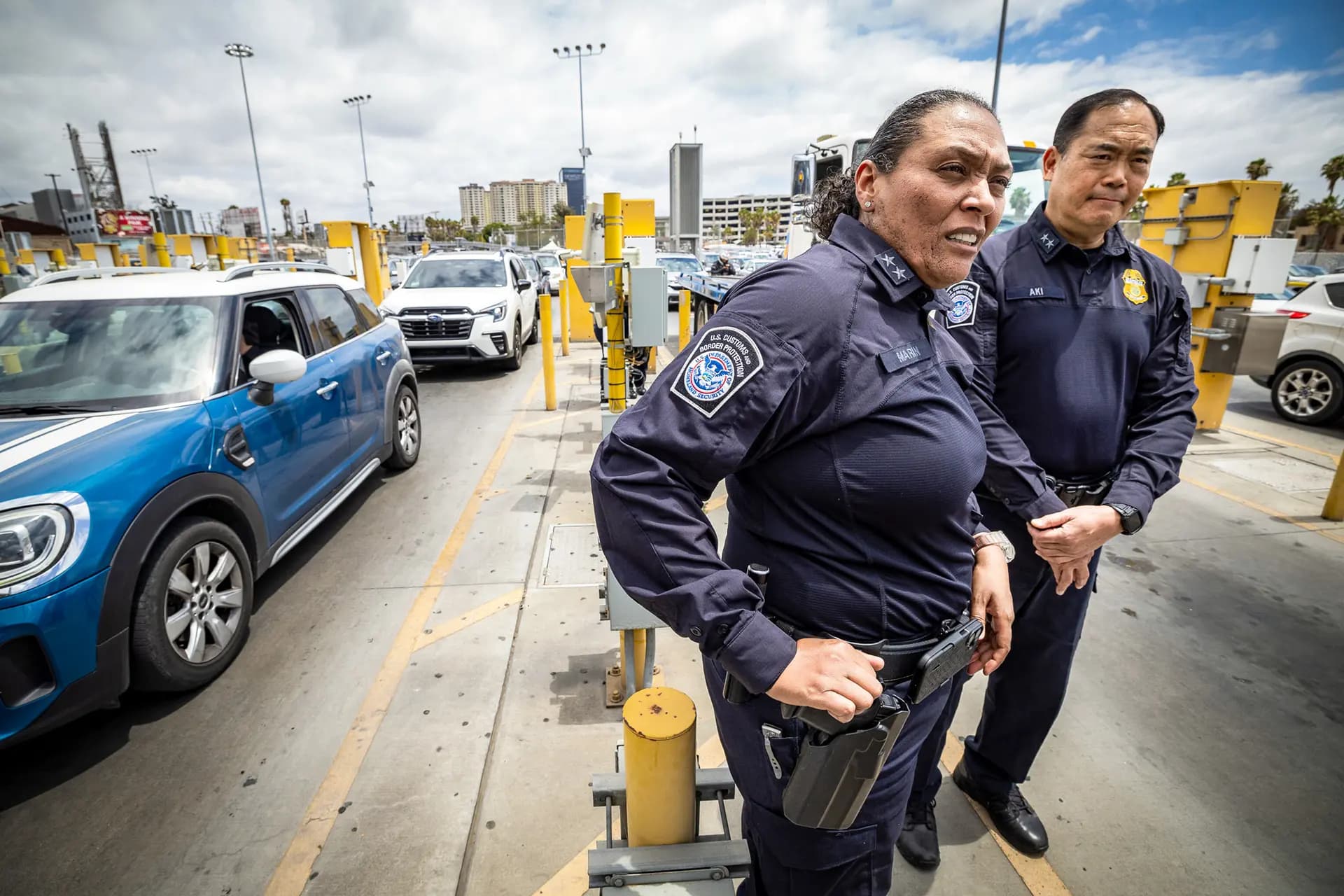 Sidney Aki, director de operaciones de campo de la oficina regional de San Diego de la Oficina de Aduanas y Protección Fronteriza (a la derecha), y Mariza Marín, directora del puerto de San Ysidro de la Oficina de Aduanas y Protección Fronteriza, observan las entradas fronterizas en el puerto de entrada de San Ysidro, en las afueras de San Diego, el 26 de mayo de 2026. (John Fredricks/The Epoch Times).