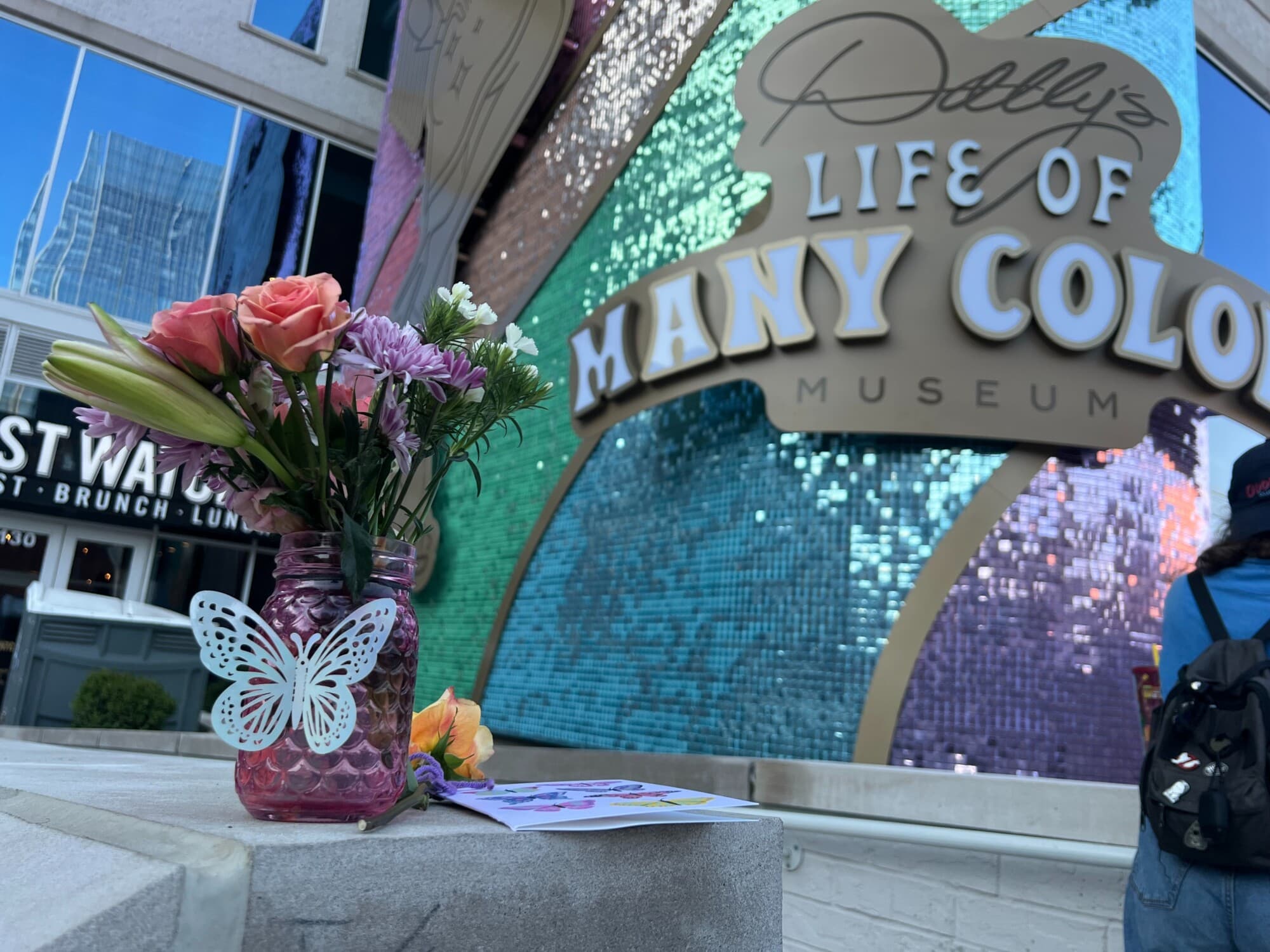 Flores y una tarjeta dejadas por un fan a las afueras del SongTeller Hotel de Dolly Parton, cuya inauguración está prevista para el otoño de 2026, en Nashville, el 25 de agosto de 2026. (Jacki Thrapp/The Epoch Times).