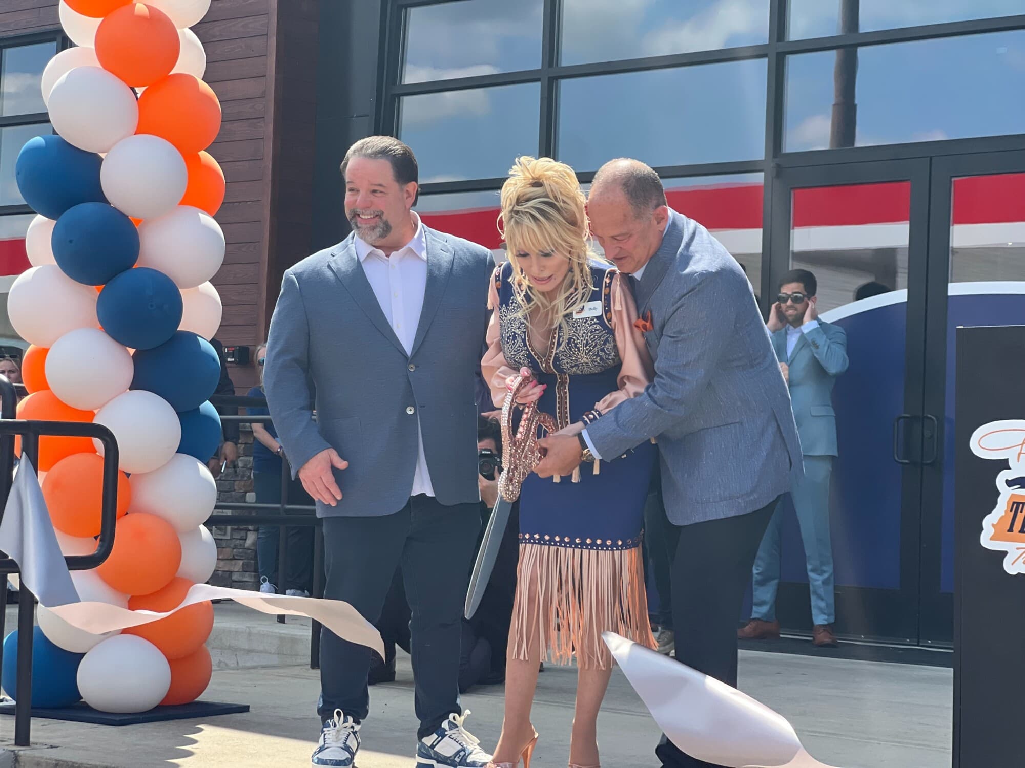 Dolly Parton y su socio comercial, Gregory H. Sachs, cortaron la cinta inaugural de su nueva estación de servicio para camiones en Cornersville, Tennessee, el 24 de junio de 2026. (Jacki Thrapp/The Epoch Times).