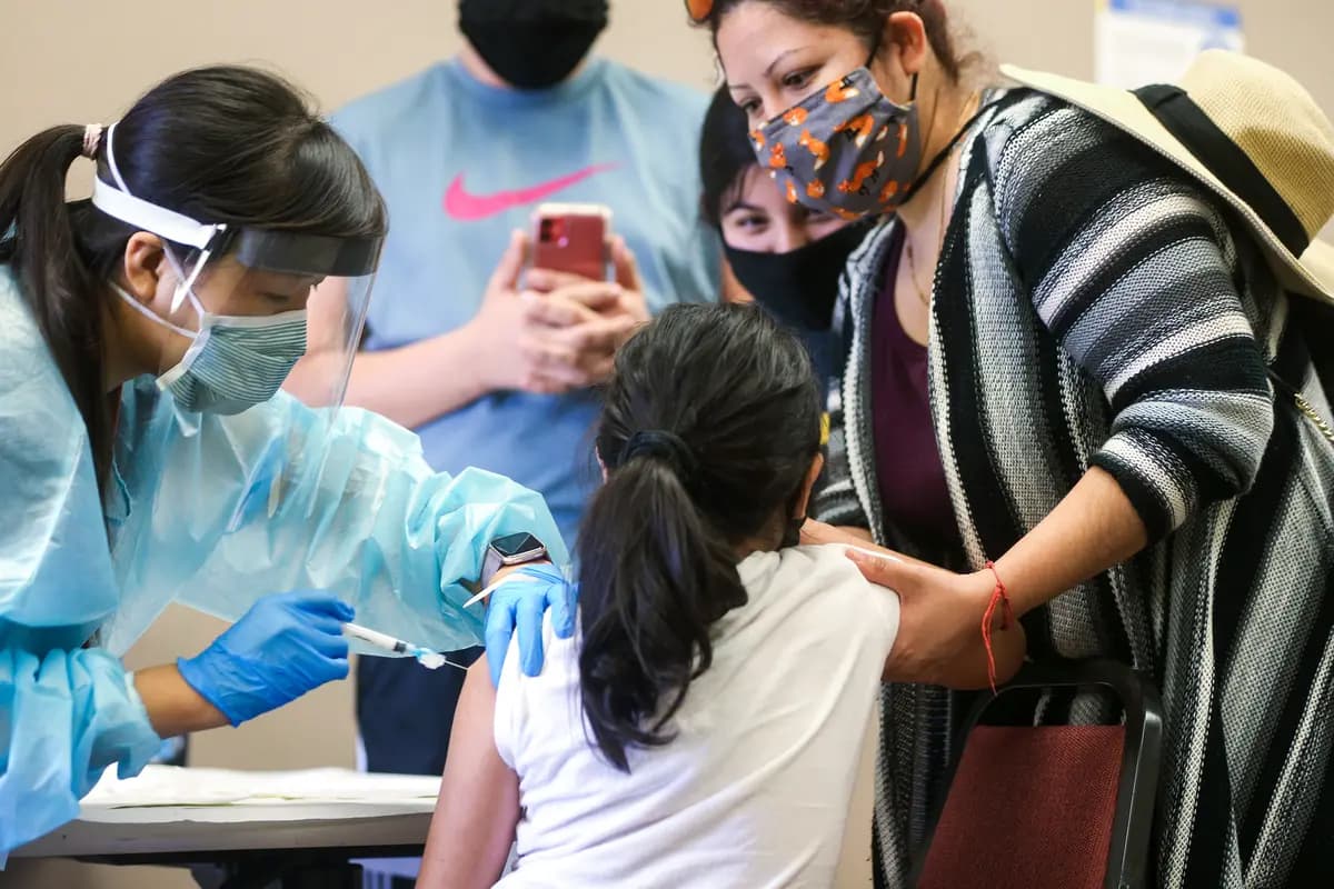 <em>Una niña recibe la vacuna contra la gripe de una enfermera en una clínica gratuita ubicada en una biblioteca local en Lakewood, California, el 14 de octubre de 2020. (Mario Tama/Getty Images).</em>