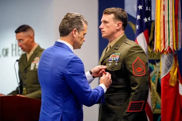 El secretario de Guerra, Pete Hegseth (izquierda), le coloca una medalla al sargento general de la Infantería de Marina Jonathan Eby (derecha) durante un evento para honrar a los marines que prestaban servicio durante el atentado con bomba de Abbey Gate de 2021, en el Pentágono, en Arlington, Virginia, el 26 de agosto de 2026. (Andrew Harnik/Getty Images)