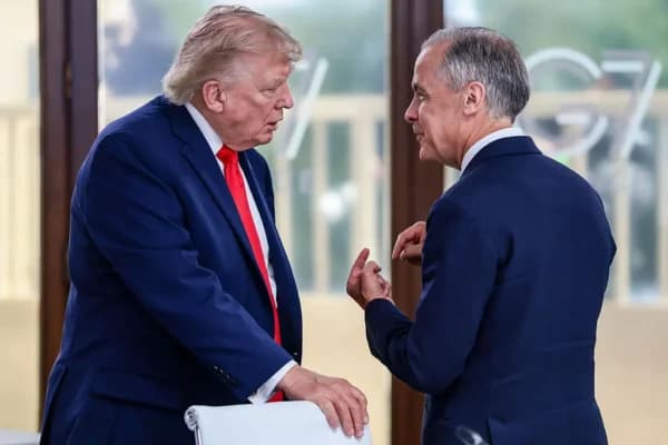 El presidente de EE. UU., Donald Trump, conversa con el primer ministro canadiense, Mark Carney, durante un almuerzo de trabajo en el marco de la cumbre del G7, en Evian, Francia, el 16 de junio de 2026. (Evelyn Hockstein/POOL/AFP vía Getty Images)