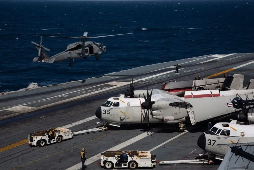 Un helicóptero MH-60S Hawk de la Armada de los Estados Unidos (izquierda) se prepara para aterrizar mientras un C-2 Greyhound se prepara en la cubierta de vuelo del USS Nimitz, frente a la costa de Busan, el 27 de marzo de 2023. (Jeon Heon-Kyun/AFP vía Getty Images)