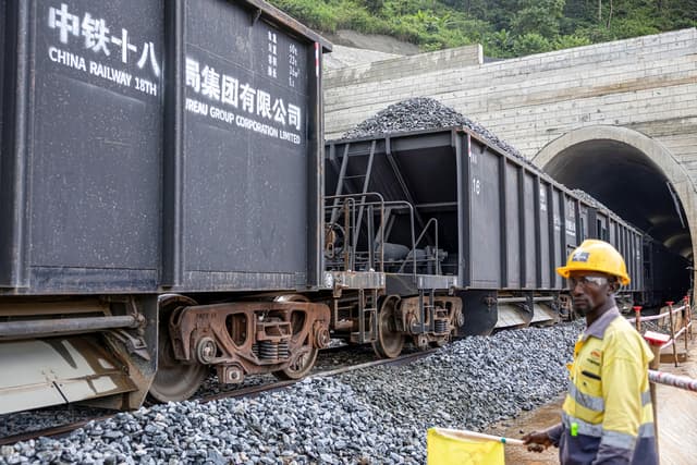 Un empleado de China Railway observa cómo un tren transporta rocas en el complejo minero SimFer, en la cordillera de Simandou, en Guinea, el 2 de septiembre de 2025. (Patrick Meinhardt/AFP vía Getty Images)