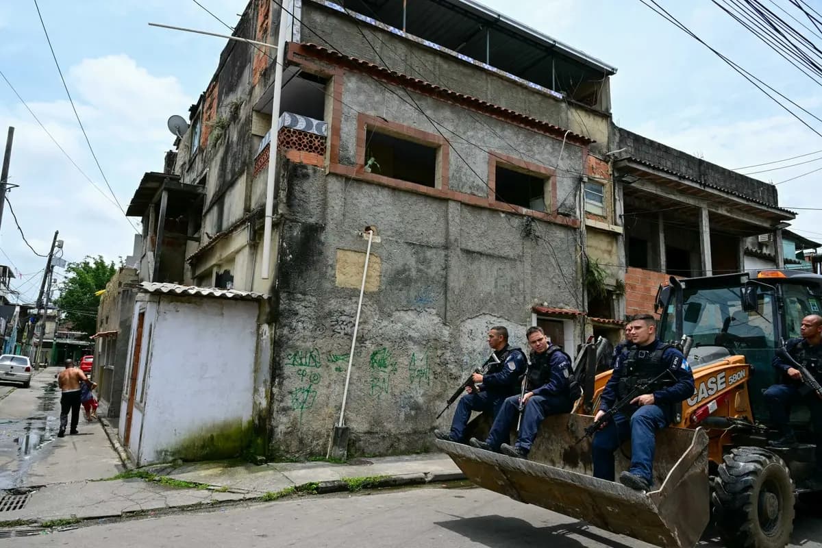 Agentes de la policía militar son transportados en una retroexcavadora durante una operación para desmantelar barricadas instaladas por delincuentes en la favela Cidade de Deus, en Río de Janeiro, Brasil, el 24 de noviembre de 2025. (Pablo Porciuncula/AFP vía Getty Images)