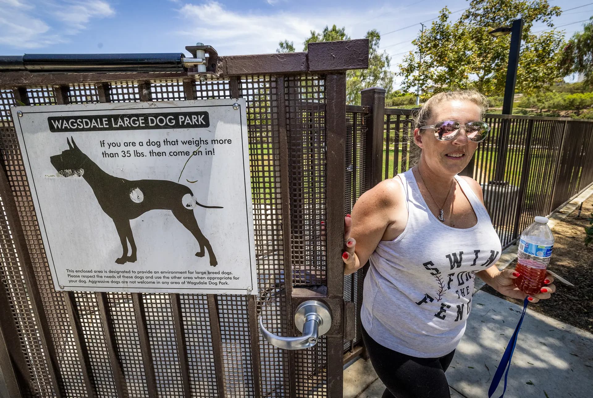 Courtney Harris sale de un parque para perros en Ladera Ranch, California, el 24 de julio de 2026. Harris dijo que después que su familia se mudara a Ladera en 2019, sus dos perros desarrollaron misteriosas convulsiones después de comer hierba afuera de su complejo de apartamentos. (John Fredricks/The Epoch Times)
