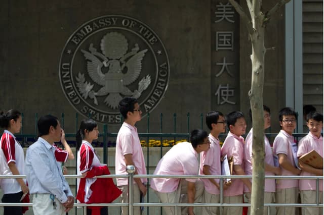 Estudiantes chinos esperan fuera de la Embajada de Estados Unidos para sus entrevistas de solicitud de visa en Pekín el 2 de mayo de 2012. (Alexander F. Yuan/AP Photo).
