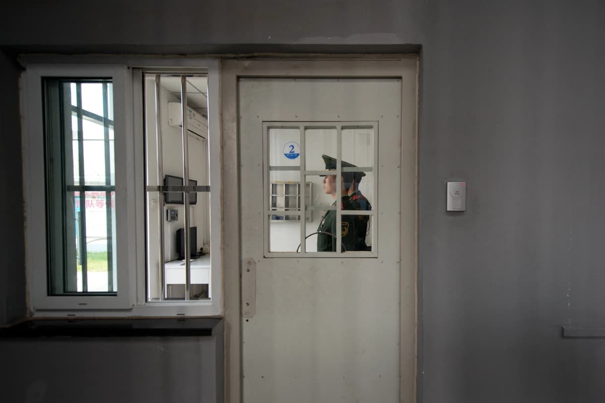 Un guardia paramilitar se encuentra junto a una puerta de seguridad dentro del Centro de Detención N.º 1 durante una visita guiada por el gobierno en Beijing el 25 de octubre de 2012. (Ed Jones/AFP vía Getty Images)