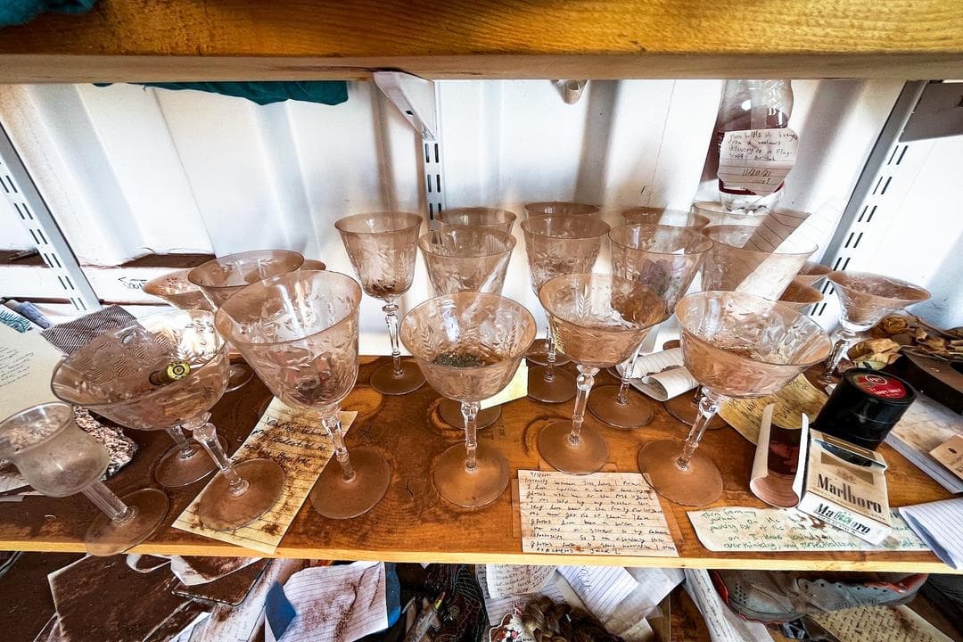 Un juego de vasos de vidrio dejado como mensaje de despedida en el Plotz Plot, el 8 de julio de 2026. (Allan Stein/The Epoch Times)