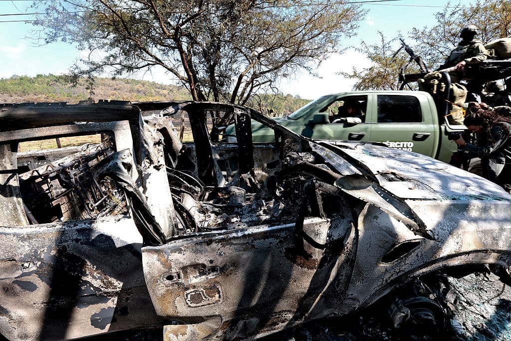<em>Miembros del Ejército junto a un vehículo incendiado utilizado para bloquear carreteras durante la huida del Mencho, cerca del Tapalpa Country Club, donde se ocultaba durante la operación por la que fue informada su muerte, en Tapalpa, Jalisco, México, el 24 de febrero de 2026. (Ulises Ruiz / AFP vía Getty Images)</em>