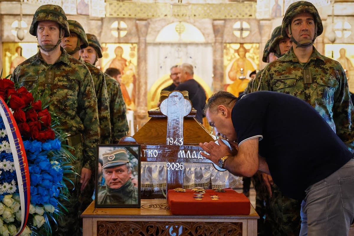 Un hombre toca la cruz —mientras soldados serbios flanquean el ataúd del excomandante del ejército serbobosnio Ratko Mladic, quien falleció la semana pasada mientras cumplía una condena a cadena perpetua por genocidio— en la iglesia de San Luka, en Belgrado, Serbia, el 7 de septiembre de 2026. (Marko Drobnjakovic/AP)