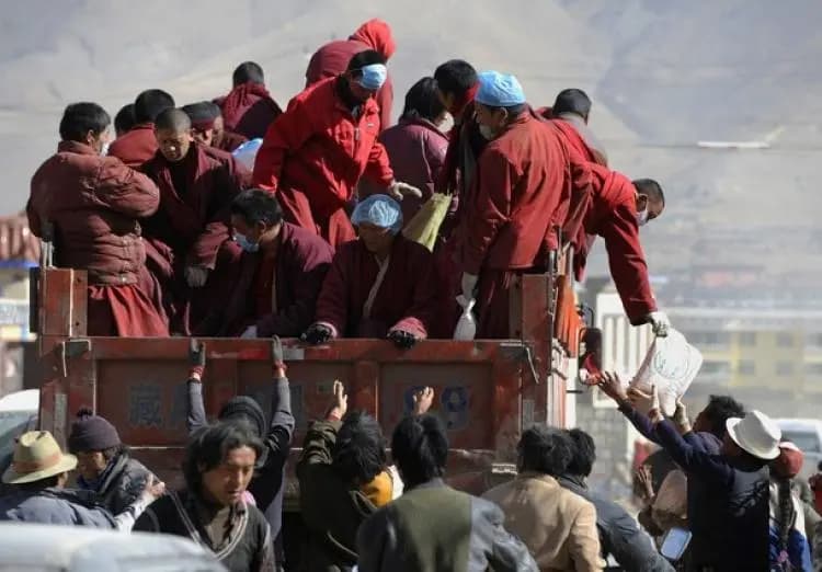 Monjes budistas tibetanos distribuyen artículos de ayuda humanitaria desde un camión tras un terremoto en Jiegu, condado de Yushu, en la provincia de Qinghai, al noroeste de China, el 19 de abril de 2010. (Getty Images).