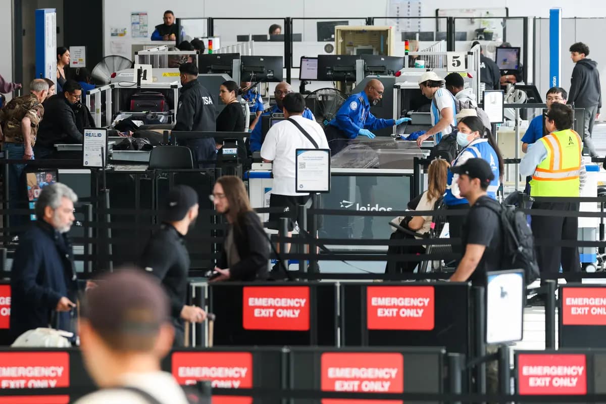 Los agentes de la TSA revisan a los pasajeros mientras estos esperan para pasar el control de seguridad en un puesto de la Administración de Seguridad en el Transporte (TSA) en el Aeropuerto Internacional de Los Ángeles, en Los Ángeles, el 23 de marzo de 2026. (Patrick T. Fallon/AFP vía Getty Images).