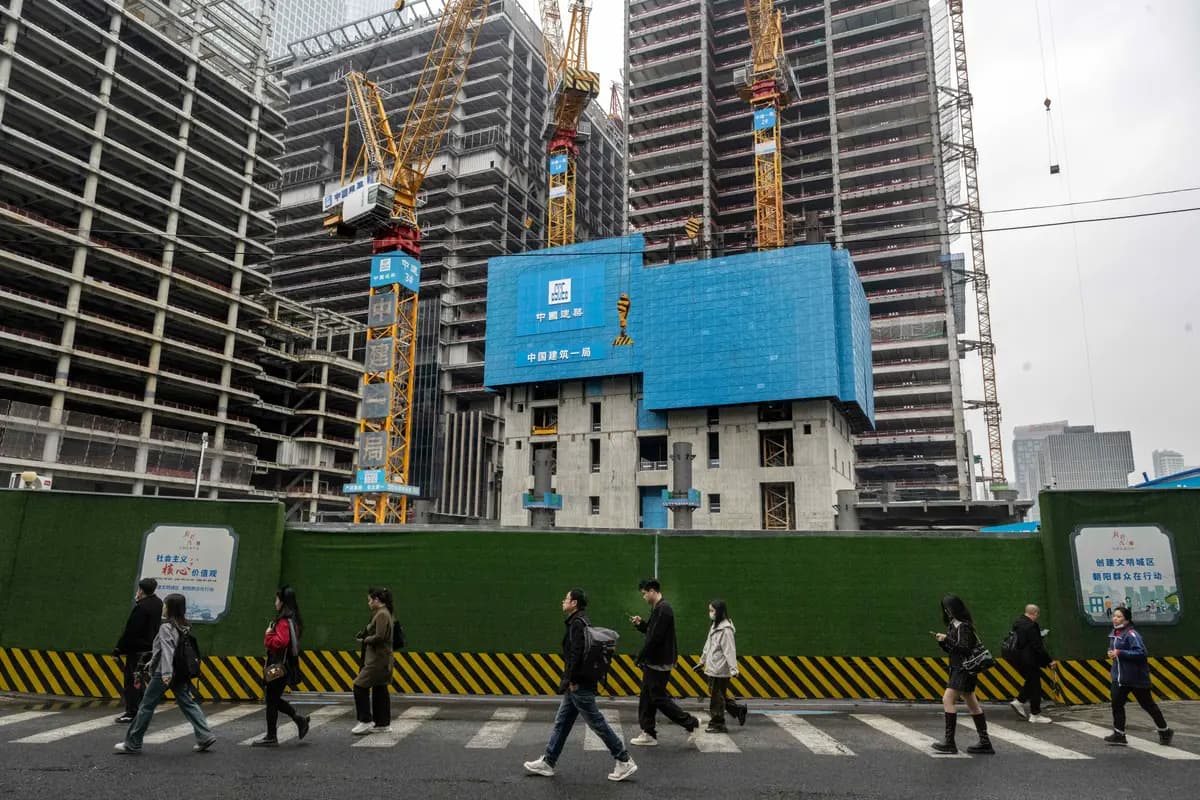 <em>Trabajadores que se dirigen al trabajo pasan junto a nuevas torres de oficinas en construcción en el distrito financiero central de Beijing, China, el 18 de octubre de 2024. (Kevin Frayer/Getty Images).</em>