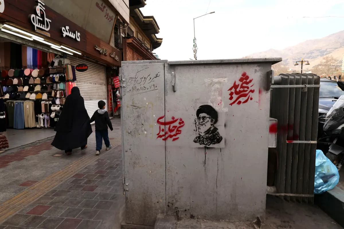Una mujer iraní toma de la mano a un niño mientras pasan junto a una tienda en una calle de la plaza Tajrish, en Teherán, el 7 de marzo de 2026. (Atta Kenare / AFP vía Getty Images)