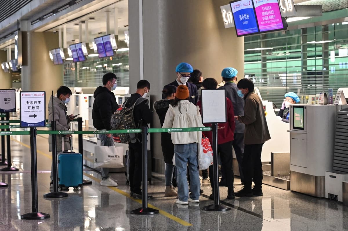 Varias personas hacen fila en los mostradores de facturación de China Eastern Airlines en el Aeropuerto Internacional de Hongqiao en Shanghái, el 21 de marzo de 2022. (Hector Retamal/AFP vía Getty Images).