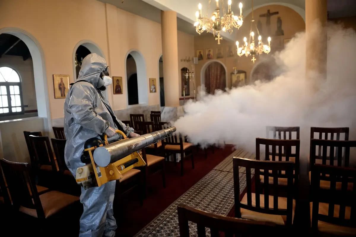 <em>Un trabajador utiliza un nebulizador térmico para desinfectar una iglesia en Salónica, Grecia, el 12 de marzo de 2020. (Sakis Mitrolidis/AFP/Getty Images).</em>