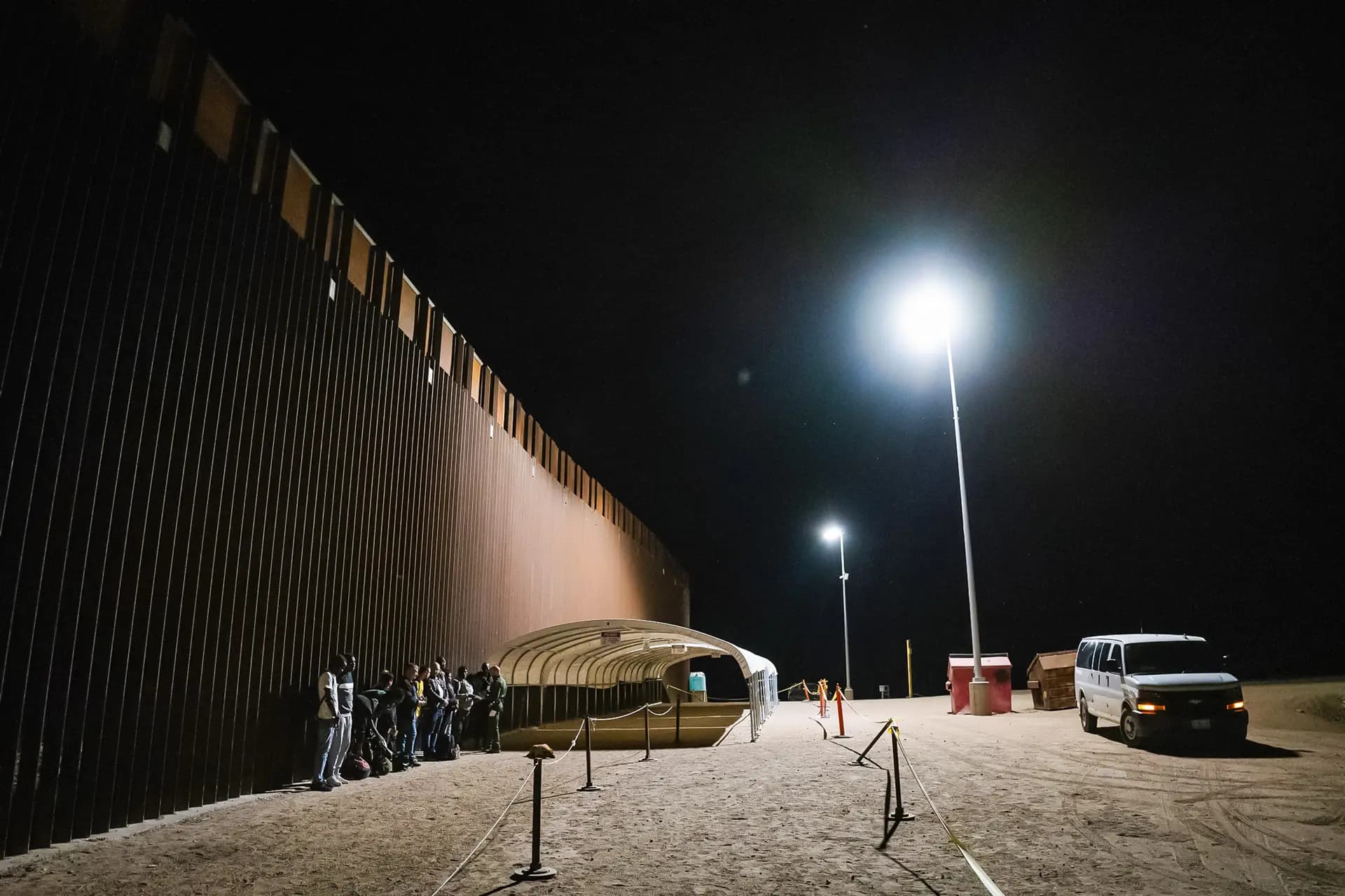 Inmigrantes indocumentados se preparan para ser transportados en autobús a centros de procesamiento en Yuma, Arizona, el 18 de mayo de 2023. (John Fredricks/The Epoch Times)