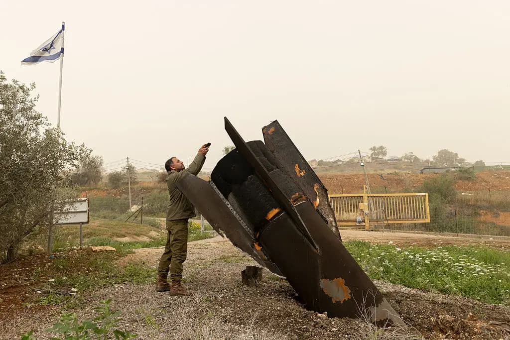 <em>Un soldado israelí toma una fotografía de la sección de cola de un misil balístico iraní en el norte del valle del Jordán el 3 de abril de 2026. (Amir Levy/Getty Images).</em>