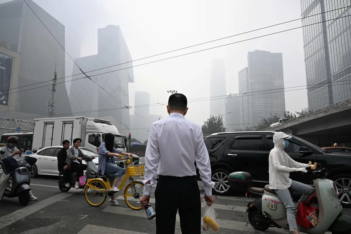<em>Un hombre espera para cruzar la calle durante un día de alta contaminación en Beijing, el 17 de septiembre de 2026. (Greg Baker/AFP).</em>