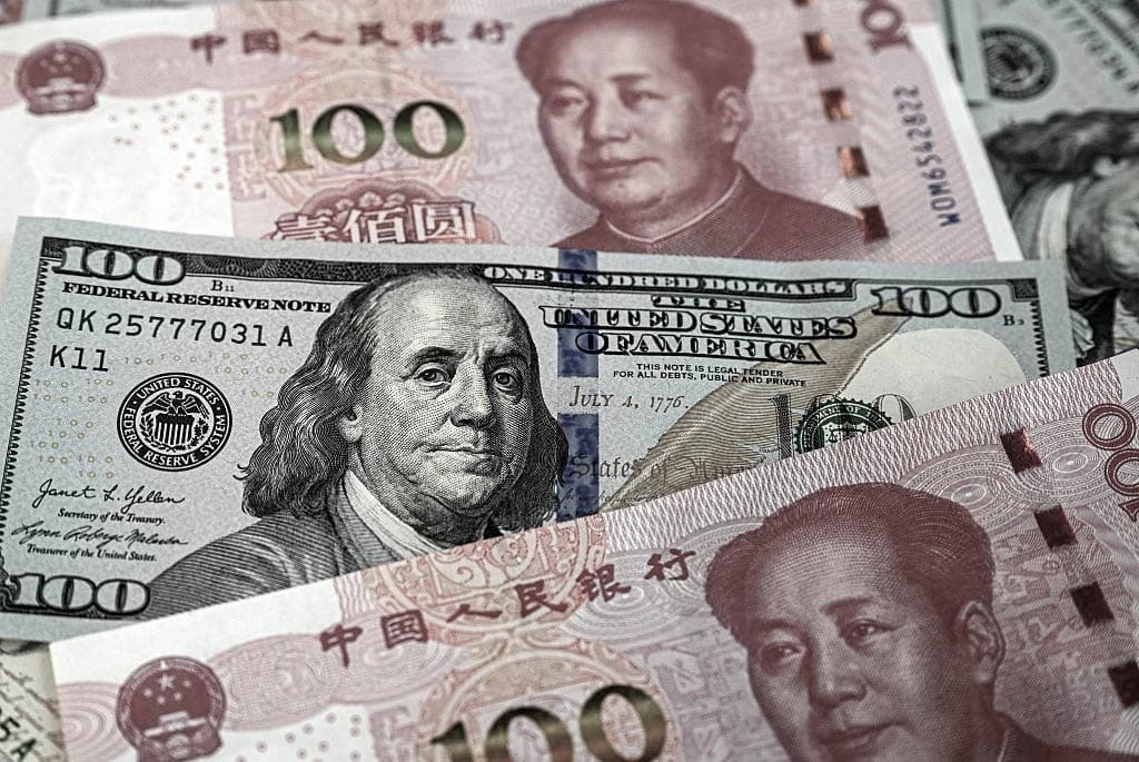 Billetes chinos de 100 yuanes y billetes de 100 dólares estadounidenses en Beijing, el 8 de abril de 2025.   (Jade Gao/AFP vía Getty Images)
