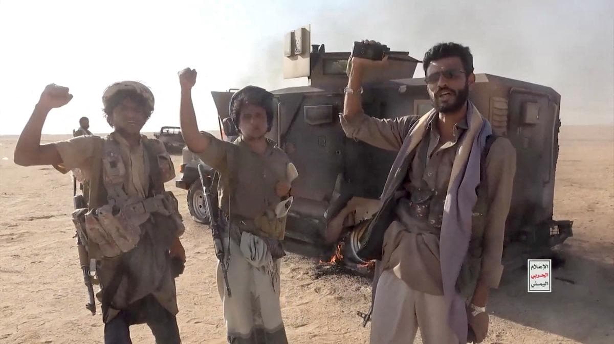 Combatientes hutíes alineados con Irán posan junto a un vehículo destruido tras lo que la fuente describió como un ataque contra fuerzas respaldadas por Arabia Saudita en la ubicación indicada por la fuente como la gobernación de al Jawf, en Yemen, en esta captura de pantalla tomada de un video difundido por los Medios Militares Hutíes el 15 de septiembre de 2026. (Medios Militares Hutíes/Reuters)
