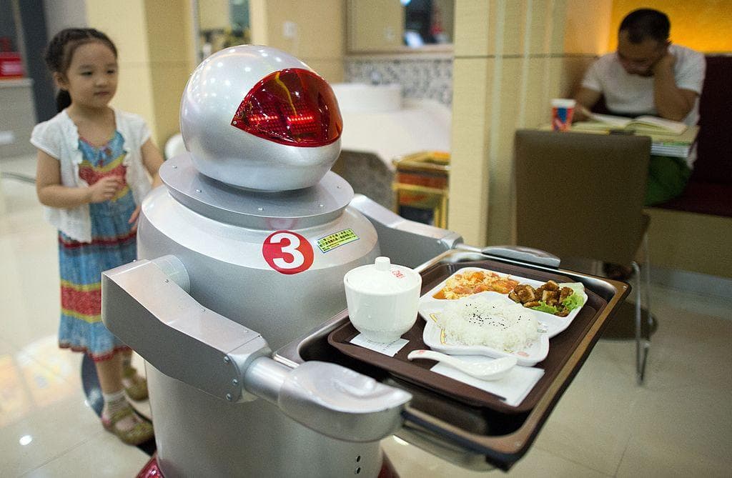 <em>Un robot repartiendo comida a los clientes en un restaurante de Kunshan el 13 de agosto de 2014. (Johannes Eiselle/AFP vía Getty Images).</em>