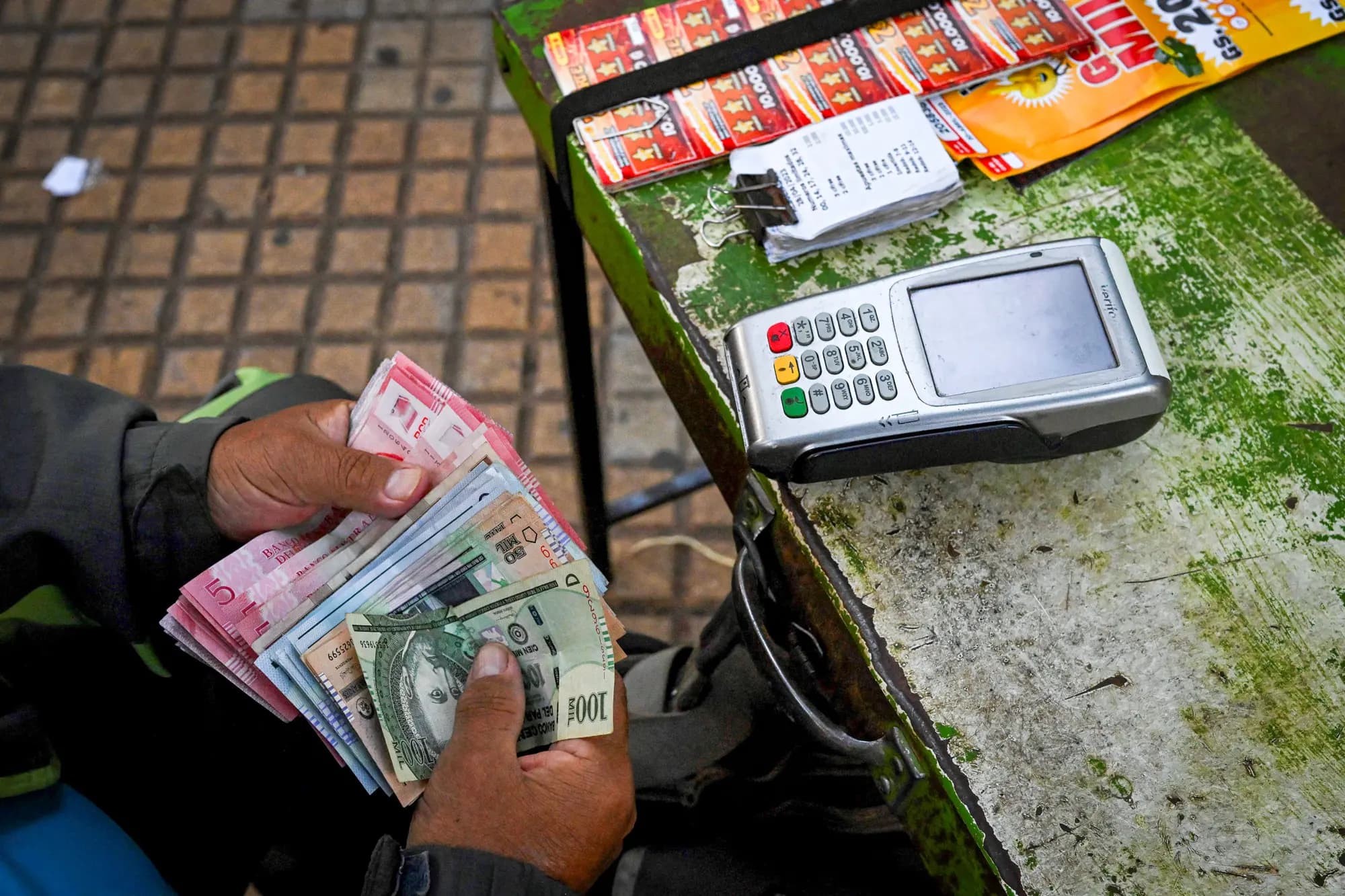 <em>Un hombre cuenta dinero en efectivo en una calle de Asunción, Paraguay, el 28 de abril de 2023. El 30 de abril de 2023, Paraguay eligió a Santiago Peña, un economista conservador de 44 años, como su presidente. (Luis Robayo/AFP vía Getty Images).</em>