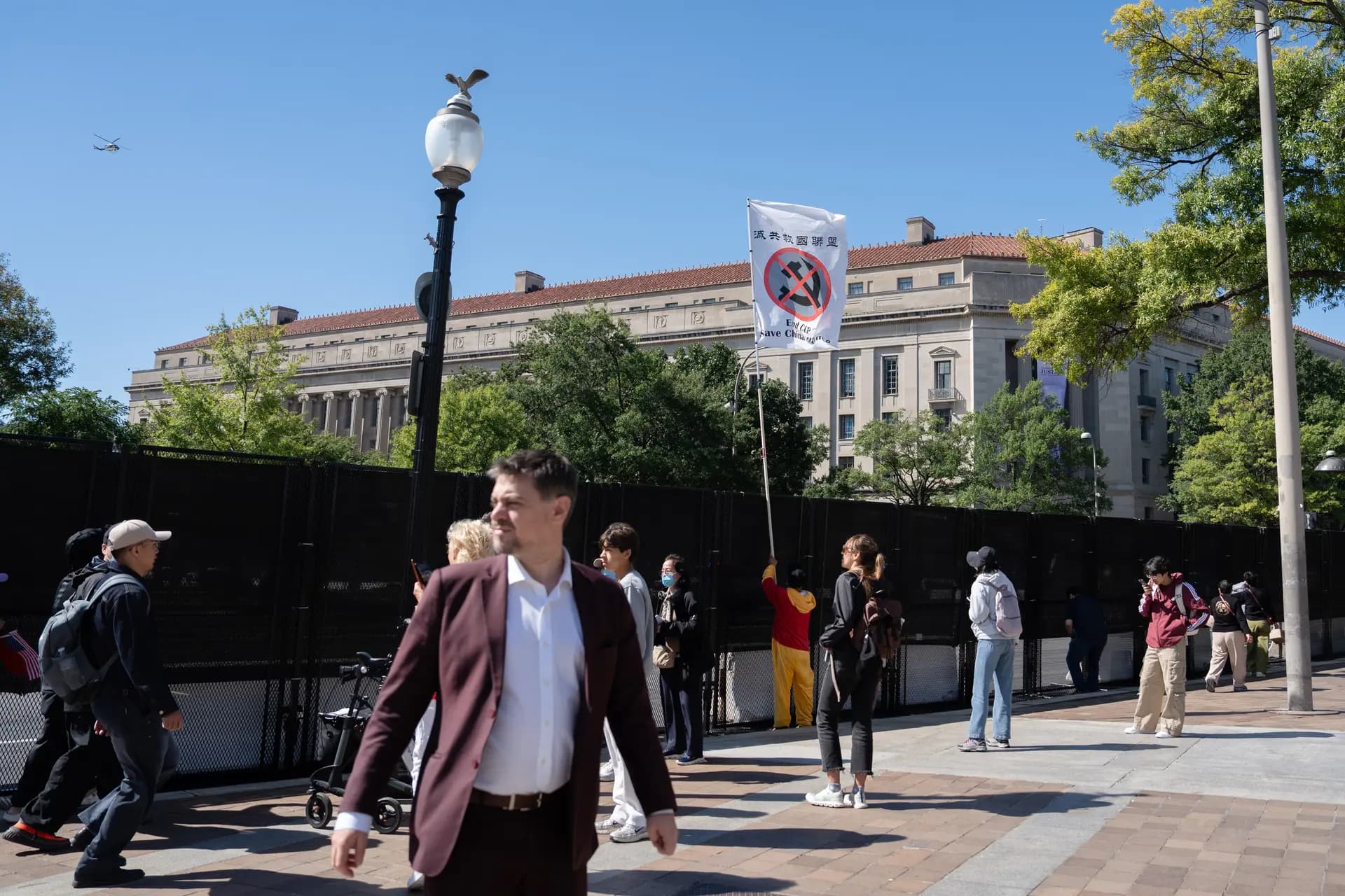 Un activista prodemocrático sostiene una bandera en contra del Partido Comunista Chinso durante la llegada del líder chino Xi Jinping a los Archivos Nacionales en Washington el 25 de septiembre de 2026. (Samira Bouaou/The Epoch Times)