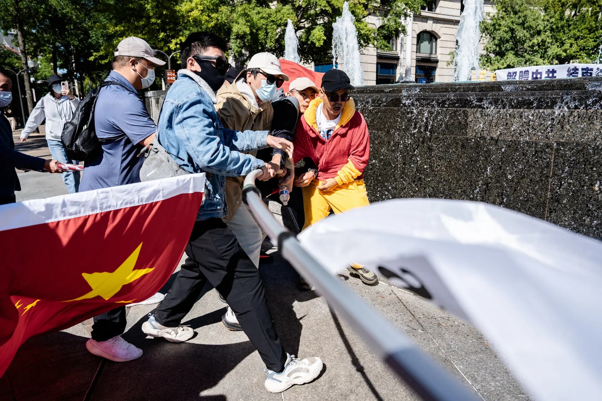 Partidarios del Partido Comunista Chino le arrebatan una bandera a un activista prodemocrático durante la llegada del líder chino Xi Jinping a los Archivos Nacionales en Washington el 25 de septiembre de 2026. (Samira Bouaou/The Epoch Times)