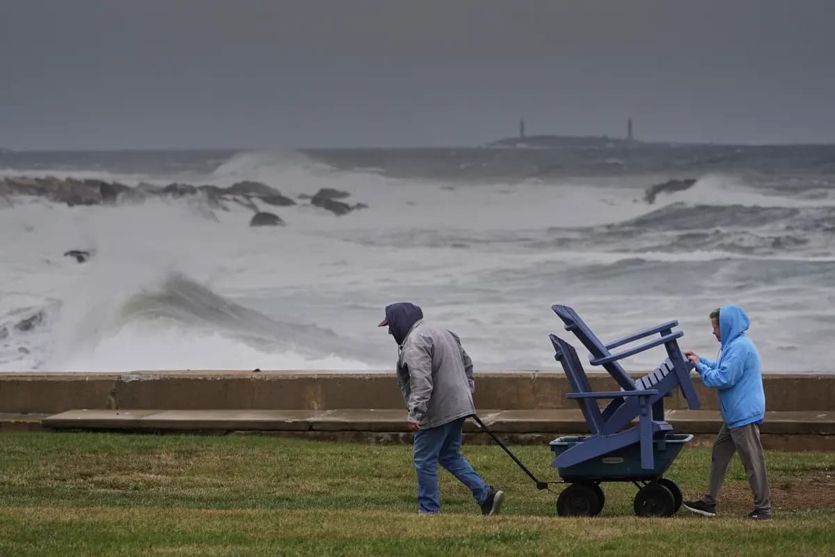 Chuck y Teresa Palmieri trasladan los muebles de jardín a un lugar seguro en la propiedad costera de un familiar mientras el océano Atlántico agita las olas durante las primeras etapas de una tormenta del noreste en Gloucester, Massachusetts, el 25 de septiembre de 2026. (Foto AP/Robert F. Bukaty)