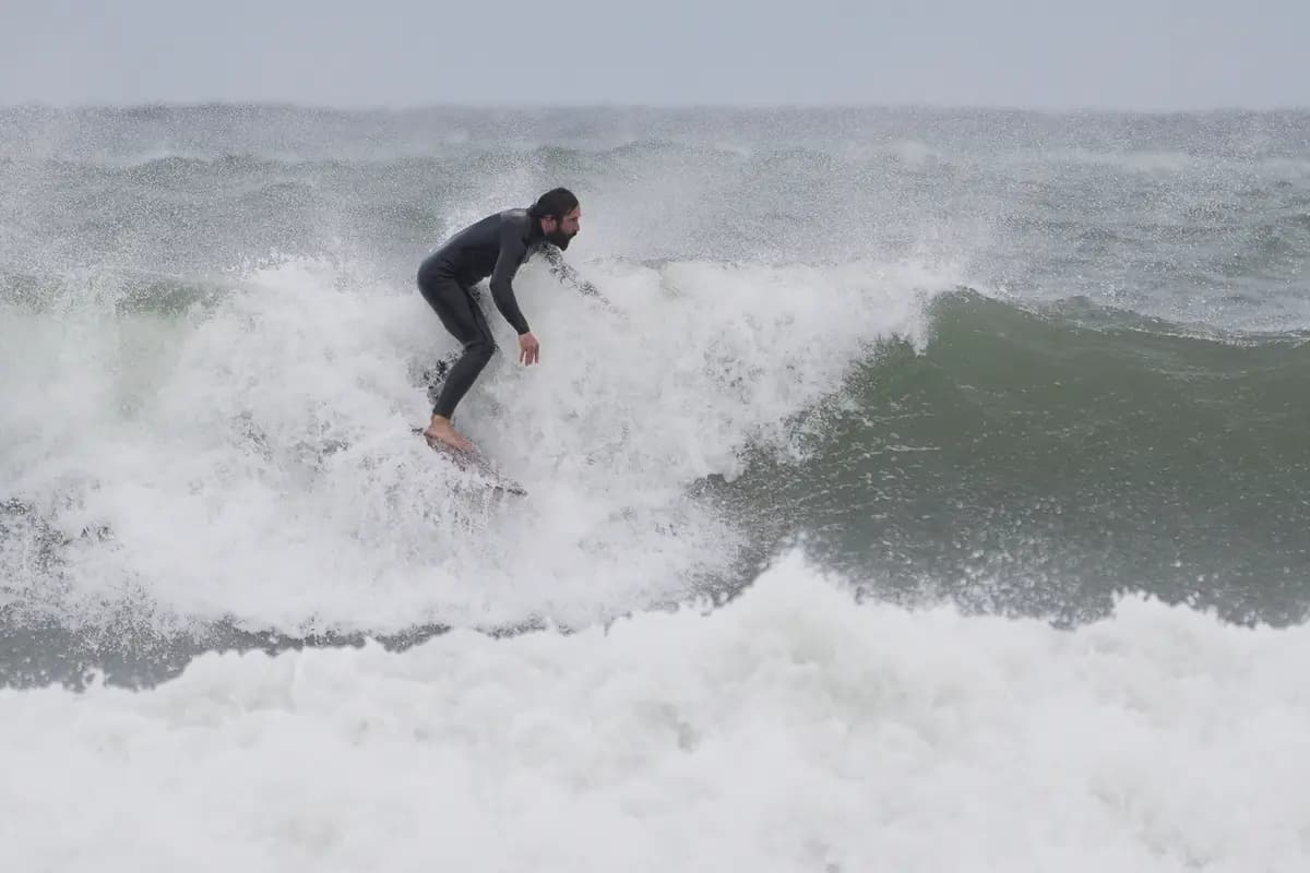 Un surfista cabalga una ola durante una tormenta del noreste en Gloucester, Massachusetts, el 25 de septiembre de 2026. (Foto AP/Robert F. Bukaty)