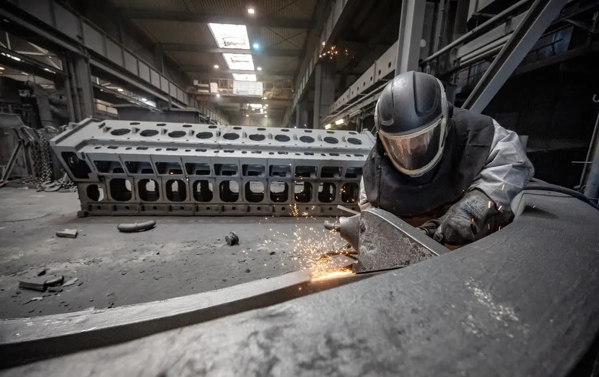Un trabajador desbarba una pieza fundida en la fundición Siempelkamp Giesserei en Krefeld, Alemania, el 21 de abril de 2022. (Sascha Schuermann/Getty Images)