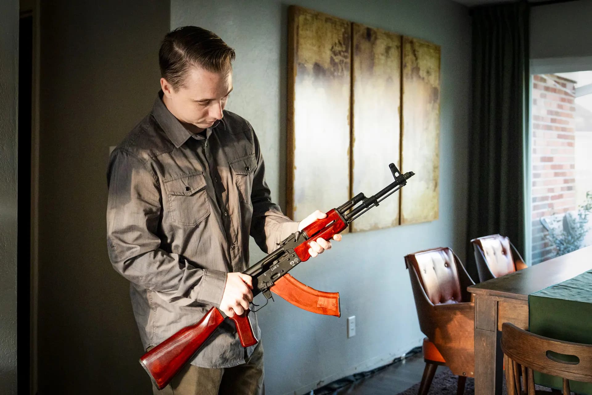Patrick "Tate" Adamiak sostiene un fusil ruso Saiga AK-47 fabricado por Izhmash en su casa en Virginia Beach, Virginia, el 21 de septiembre de 2026. (Madalina Kilroy/The Epoch Times).