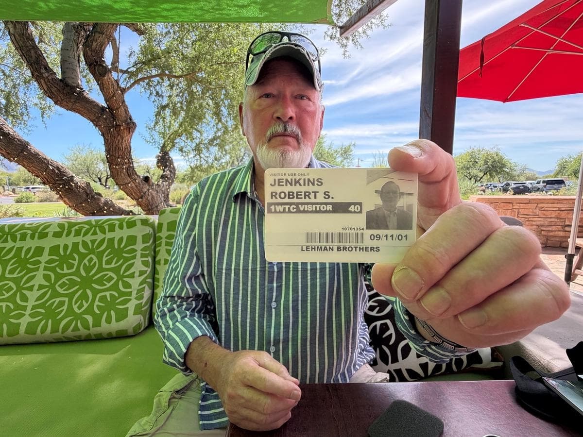 Bob Jenkins, de 71 años, sobreviviente de los ataques del 11 de septiembre de 2001 al World Trade Center, en Carefree, Arizona, el 20 de septiembre de 2026. Jenkins sostiene la tarjeta de identificación que le permitió ingresar a la torre norte apenas unos minutos antes de que el primer avión se estrellara contra ella. (Allan Stein/The Epoch Times)