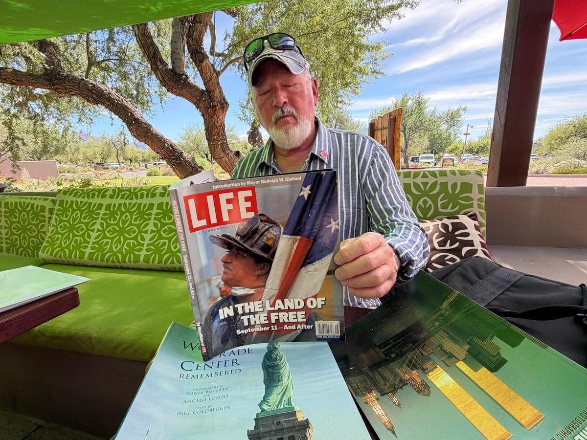 Bob Jenkins, sobreviviente del ataque al World Trade Center, lee una copia de la revista Life publicada poco después del suceso, en Carefree, Arizona, el 20 de septiembre de 2026. (Allan Stein/The Epoch Times)