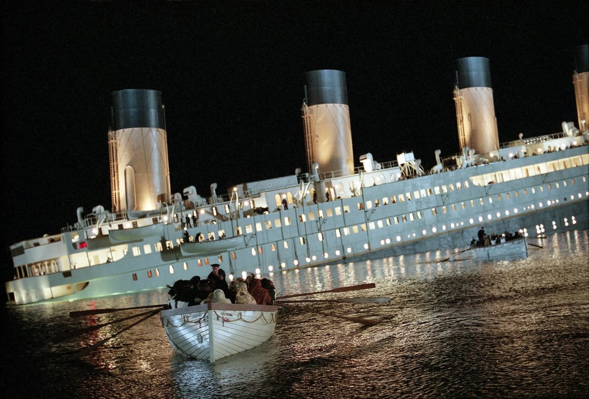 Un bote salvavidas se aleja del barco que se hunde, en "Titanic". (Paramount Pictures).