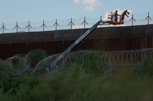 Ingenieros de combate del Ejército de EE. UU. colocan alambre de cuchillas en el muro fronterizo entre Estados Unidos y México para reforzar la seguridad en El Paso, Texas, visto desde Ciudad Juárez, México, el 24 de julio de 2025. (Jose Luis Gonzalez/Reuters).