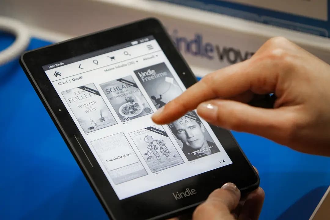 Un visitante explora libros en un lector de libros electrónicos Kindle en la Feria del Libro de Fráncfort, Alemania, el 15 de octubre de 2015. (Daniel Roland/AFP vía Getty Images)