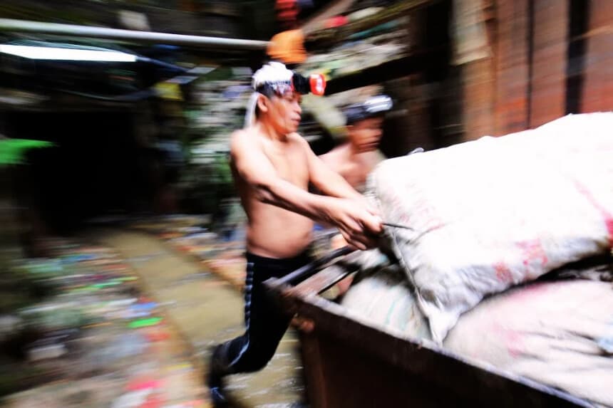 El 17 de julio de 2012 en Filipinas, unos mineros empujan un carrito.  (Foto de TED ALJIBE/AFP vía Getty Images)