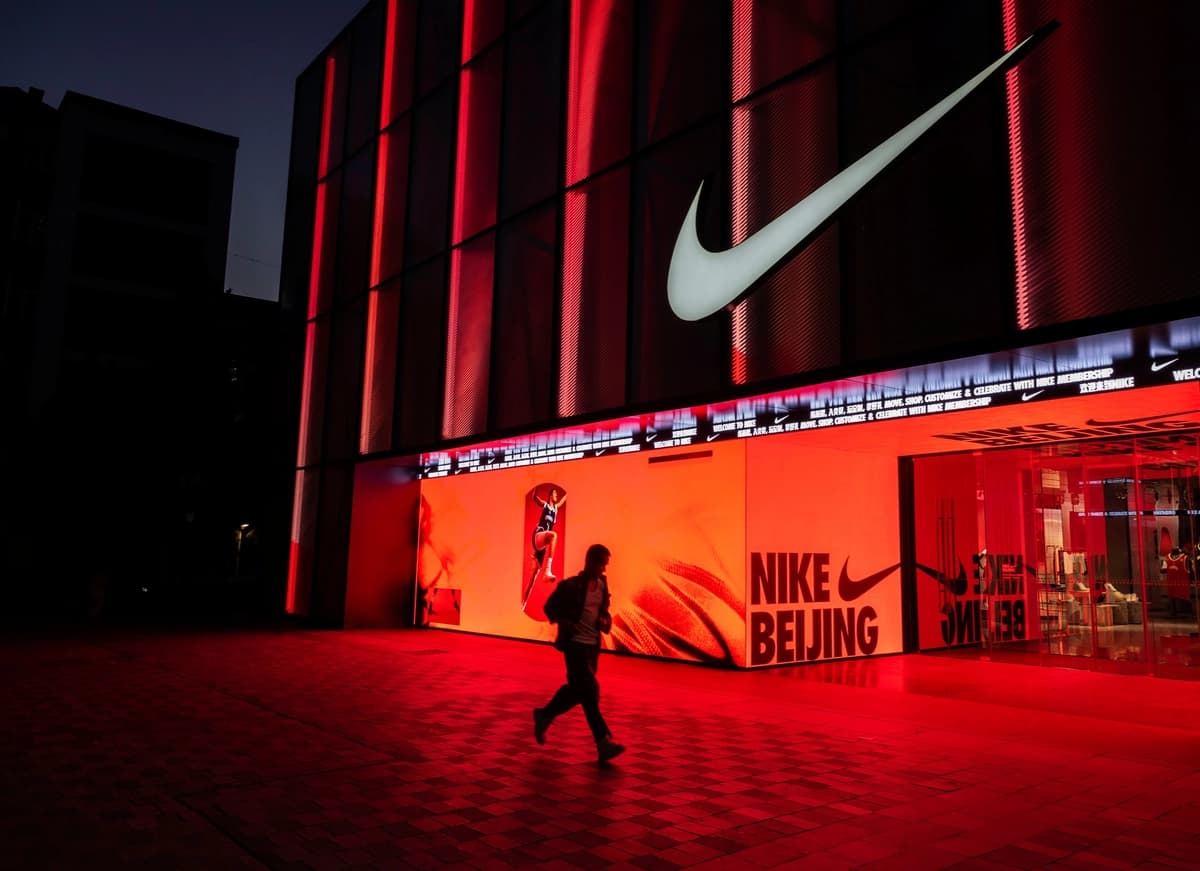 Un hombre pasa junto a una tienda de la marca deportiva Nike en una zona comercial de Beijing el 24 de abril de 2025. (Kevin Frayer/Getty Images)