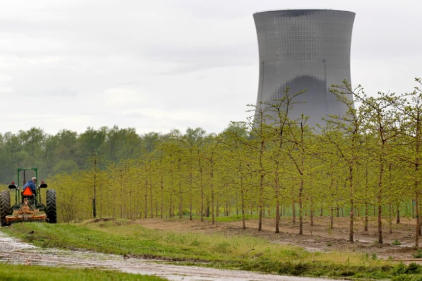 Un trabajador conduce un tractor por una plantación de árboles en North Perry, Ohio, cerca de las torres de refrigeración de la central nuclear de Perry, el 18 de mayo de 2011. (Amy Sancetta, archivo/AP).