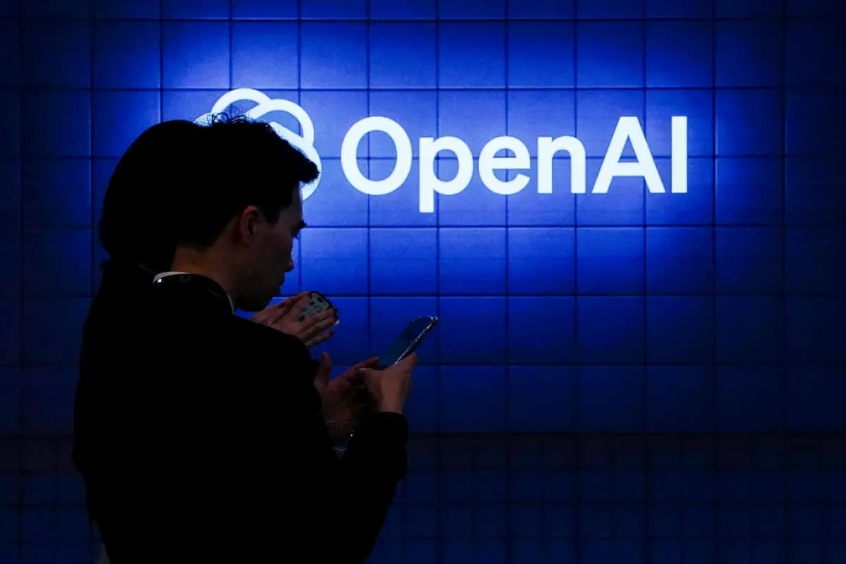 Un visitante mira su teléfono junto al logotipo de OpenAI durante el Mobile World Congress, el encuentro anual más importante de la industria de las telecomunicaciones, en Barcelona el 26 de febrero de 2024. (Pau Barrena/AFP vía Getty Images)