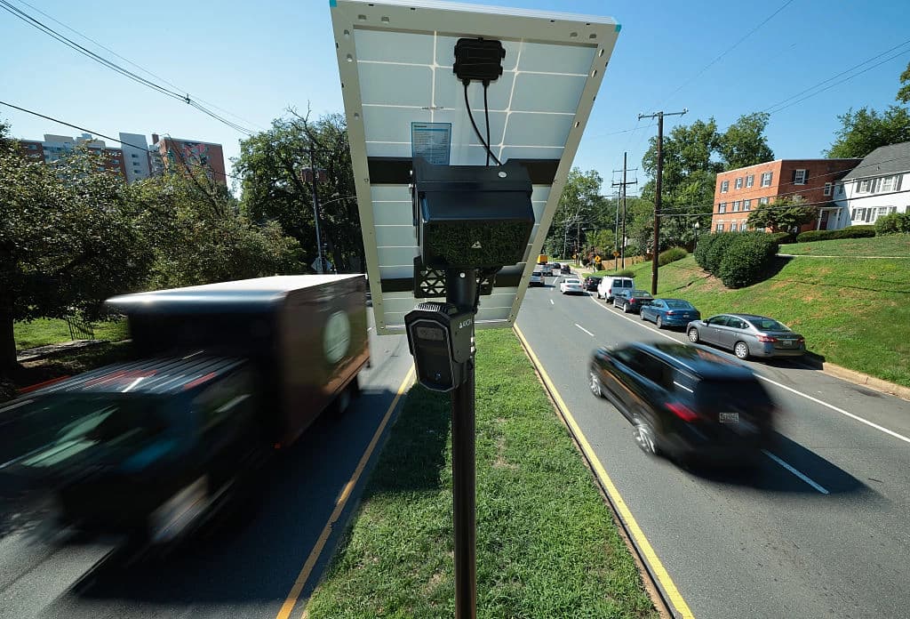 El tráfico pasa junto a una cámara lectora automática de matrículas de la marca Axon en la mediana de la calle 16, cerca del límite entre Maryland y el Distrito de Columbia, el 19 de agosto de 2026. (Chip Somodevilla/Getty Images).