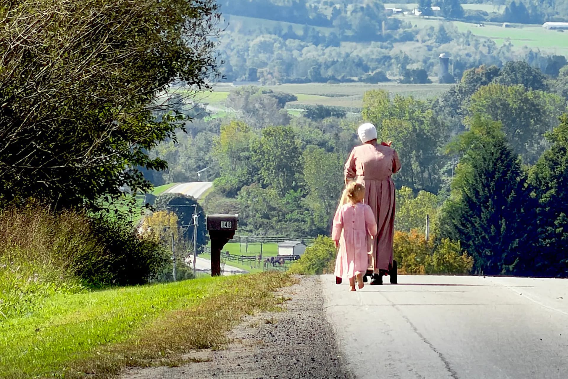 Una niña amish camina descalza detrás de su madre cerca de Cooperstown, Nueva York, el 18 de septiembre de 2026. (Allan Stein/The Epoch Times).