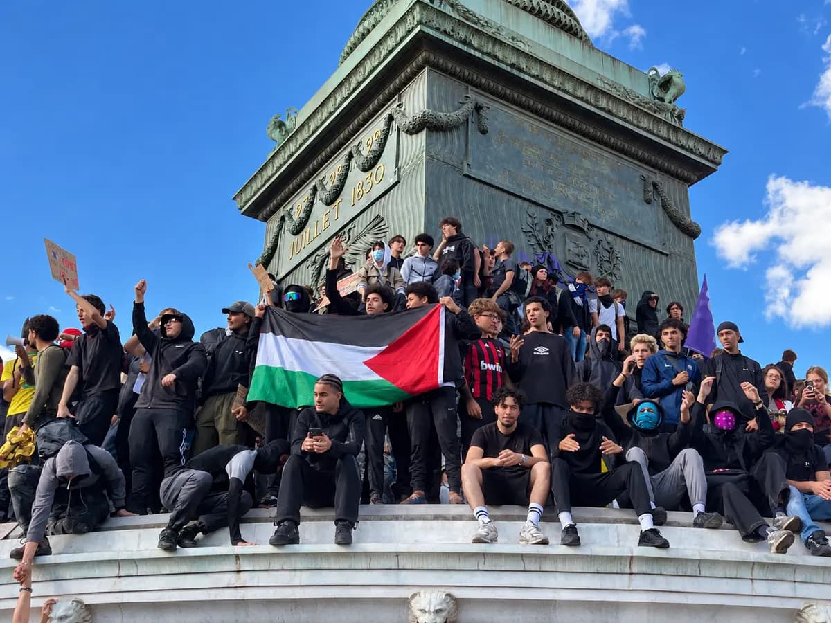 Manifestantes, algunos con cubrebocas, se reúnen al pie de la Columna de Julio en la Plaza de la Bastilla de París, sosteniendo una bandera palestina durante una protesta de estudiantes de preparatoria en París el 8 de octubre de 2026. (Etienne Fauchaire/The Epoch Times).