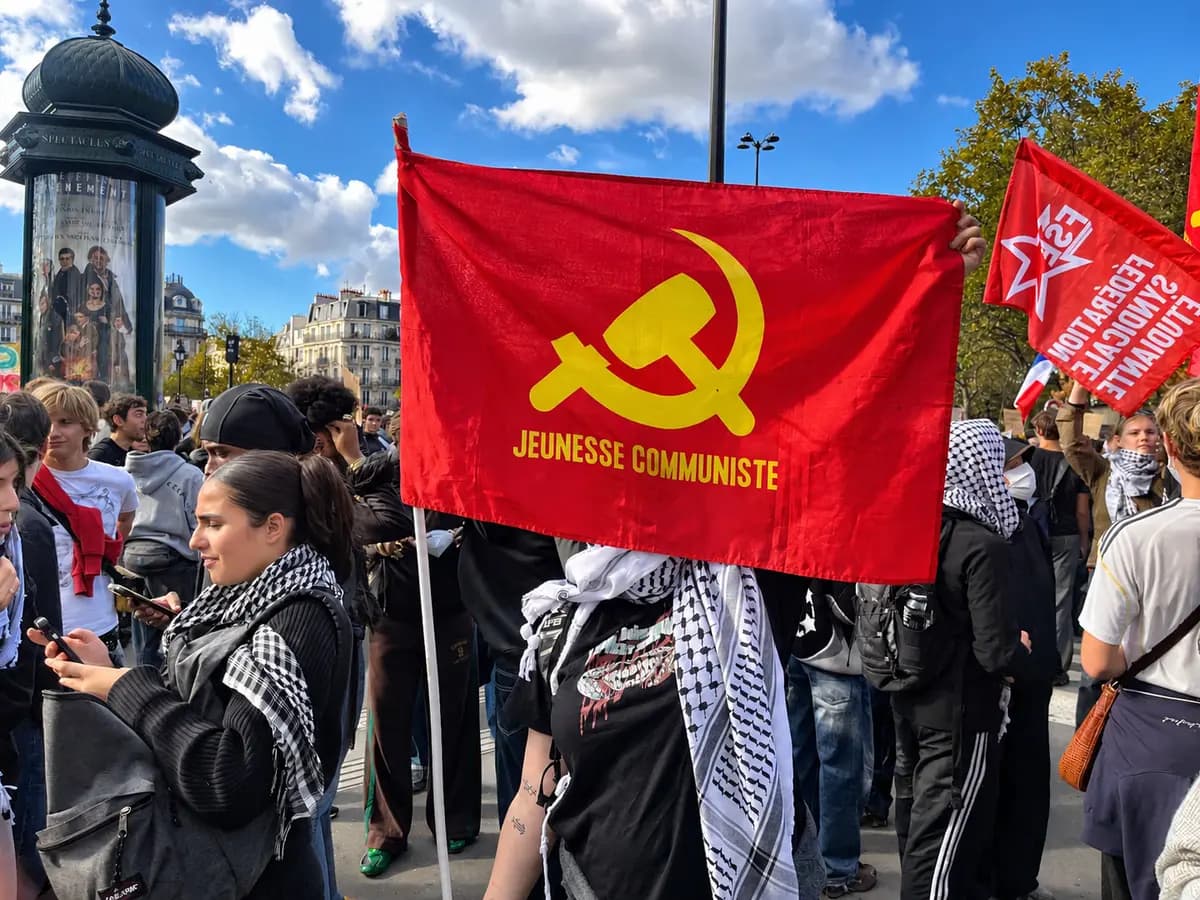 Un manifestante sostiene una bandera roja con el emblema de la hoz y el martillo del Movimiento Juvenil Comunista Francés durante una protesta de estudiantes de preparatoria en la Place de la Bastille, en París, el 8 de octubre de 2026. (Etienne Fauchaire/The Epoch Times).