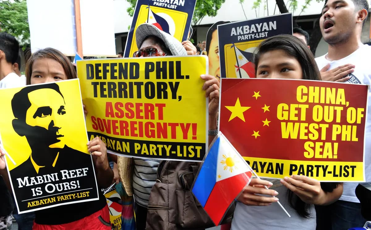 Manifestantes filipinos muestran pancartas durante una marcha en contra de las reivindicaciones de China sobre zonas del Mar de China del Sur, frente al consulado chino en Manila, el 12 de junio de 2014. (Jay Directo/AFP/Getty Images).