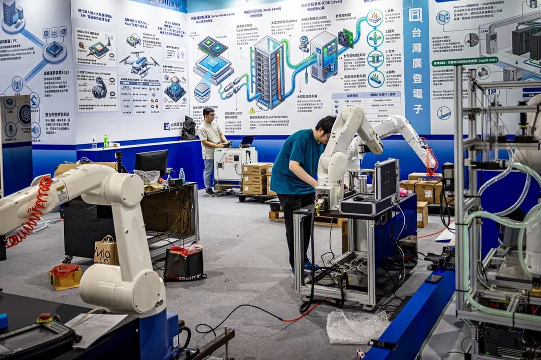 Ingenieros configuran y prueban brazos robóticos industriales en un stand durante los preparativos para la feria COMPUTEX en Taipéi, Taiwán, el 1 de junio de 2026. COMPUTEX, una de las ferias anuales de computación y tecnología más grandes del mundo, presenta chips de IA de última generación, robótica e infraestructura computacional. (Cheng Chia Huang/Getty Images)